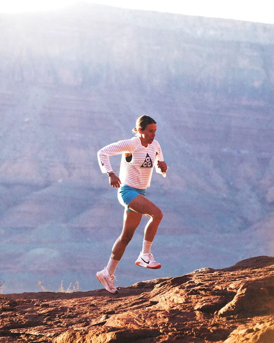 Runner leaping across red-rock terrain in the Radical AirFlow top